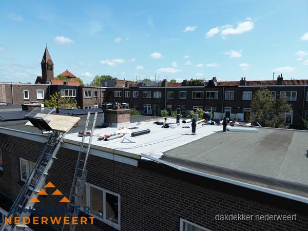 Dakdekkers aan het werk op plat dak in Nederweert