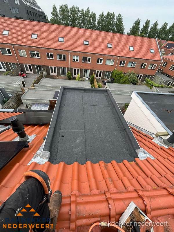 Bitumen dak reparatie op plat dak tussen dakpannen in Nederweert