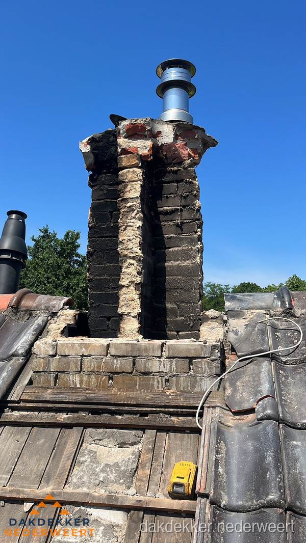 Beschadigde schoorsteen met nieuwe rookgasafvoer op oud dak in Nederweert
