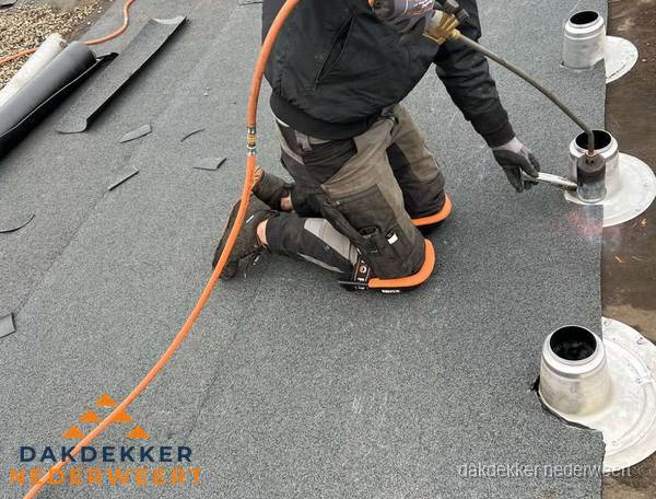 Dakdekker repareert bitumen dakleer bij dakdoorvoer in Nederweert
