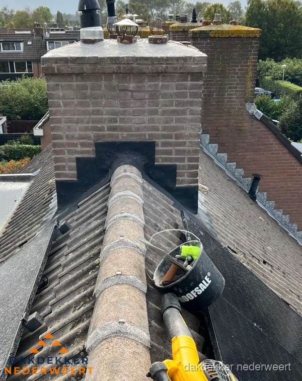 Schoorsteen met loodaansluiting en nokvorst op pannendak in Nederweert